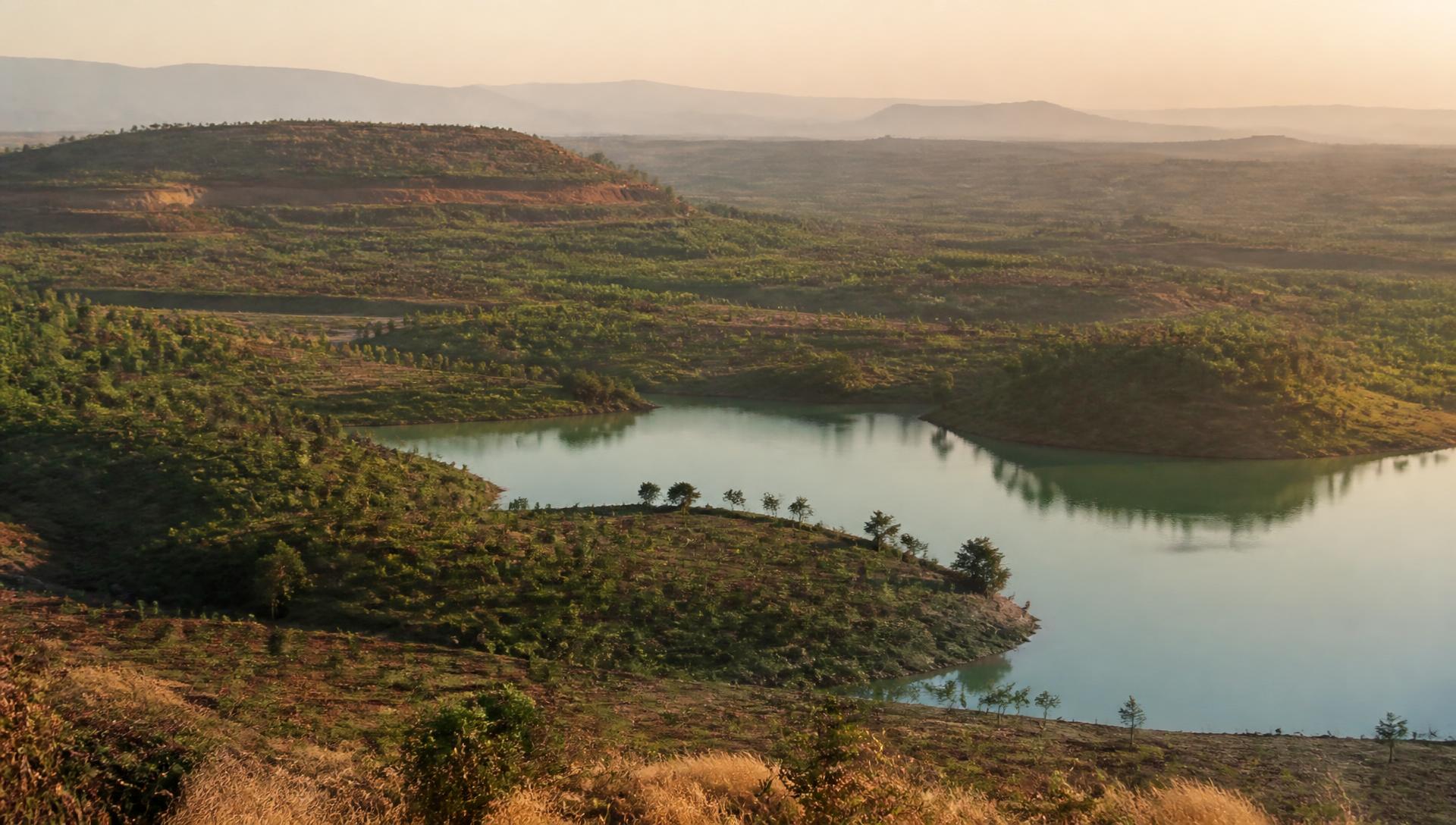 Rehabilitated mine landscape with regenerating vegetation around a restored water body
